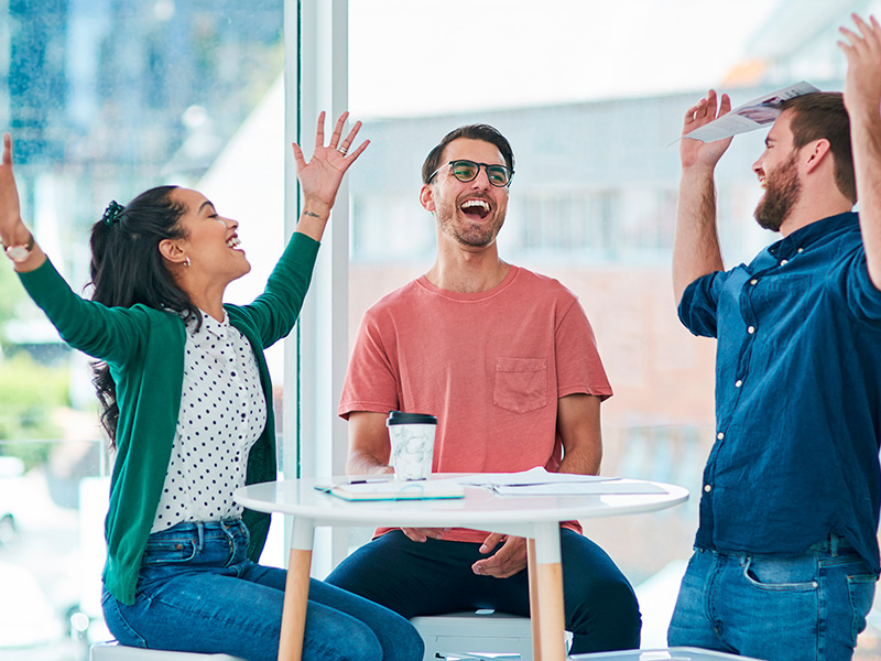 celebracion-grupal-y-documentos-en-la-oficina-en-la-puesta-en-marcha-trabajo-en-equipo-y-exito-con-el-proyecto-en-la-empresa-personas-hombres-y-mujeres-con-co