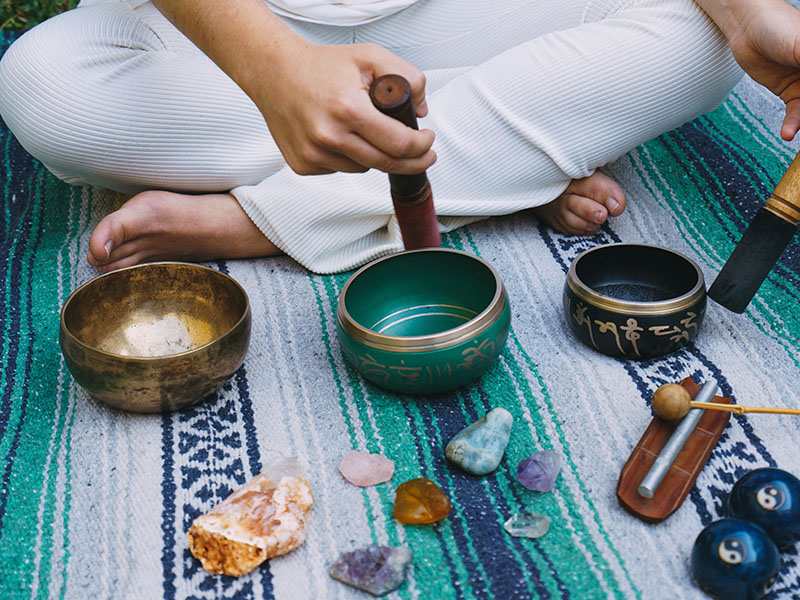 seccion-baja-del-hombre-sentado-en-una-manta-de-picnic-con-herramientas-de-meditacion