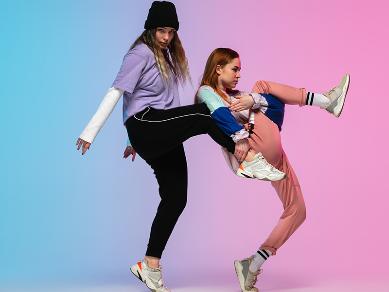 chicas-bailando-hiphop-con-ropa-elegante-en-un-fondo-degradado-en-el-salon-de-baile-con-luz-de-neon