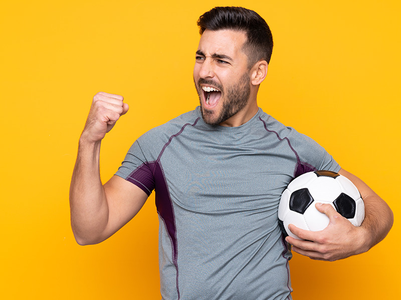 hombre-con-barba-jugando-al-futbol-sobre-pared-aislada