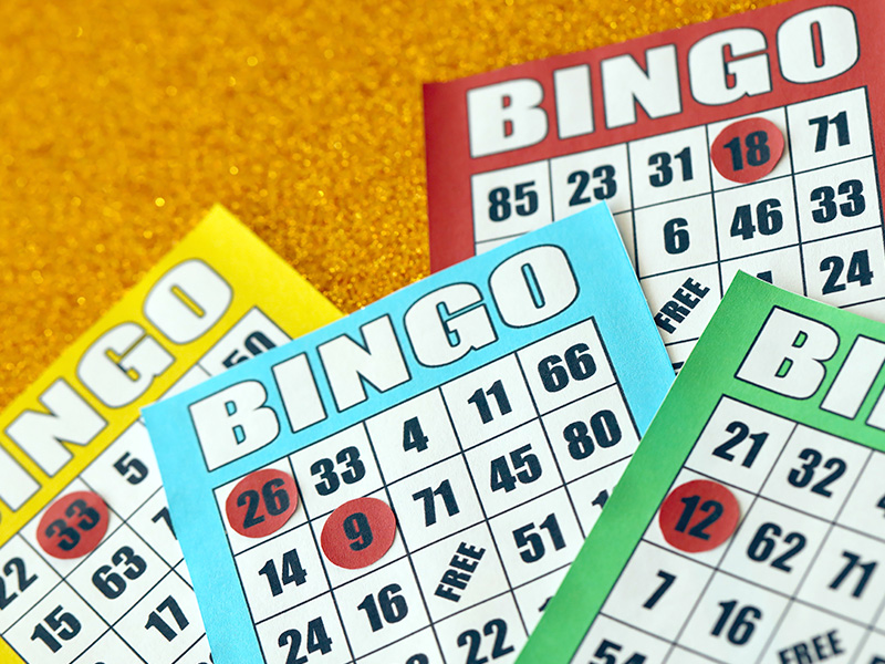 muchos-coloridos-tableros-de-bingo-o-naipes-para-ganar-fichas-clasico-estadounidense-o-canadiense-cinco-o-cinco-cartones-de-bingo-sobre-fondo-brillante