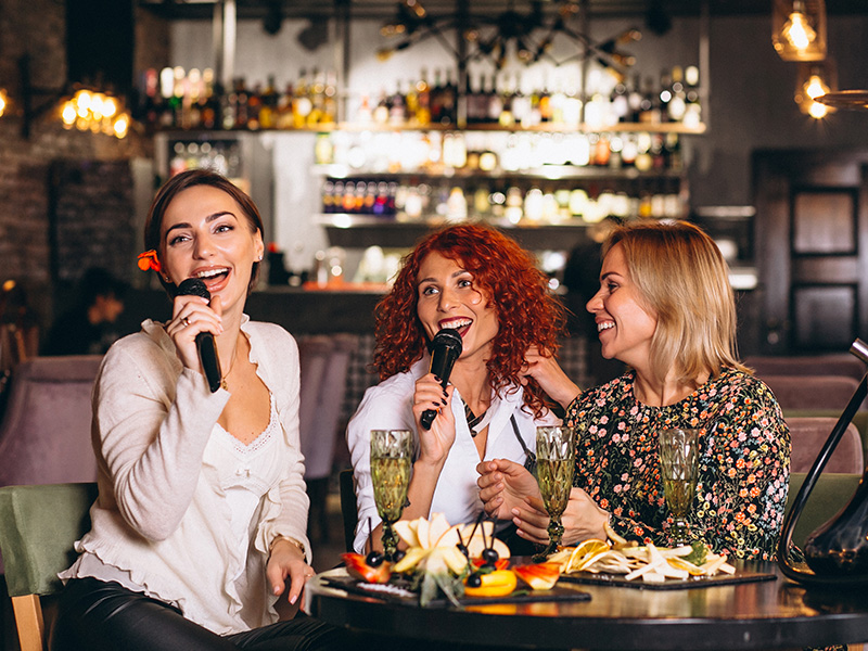 mujeres-jovenes-en-un-bar-cantando-karaoke
