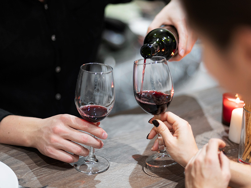 pareja-joven-celebrando-el-dia-de-san-valentin-mientras-almuerza-y-vino-juntos