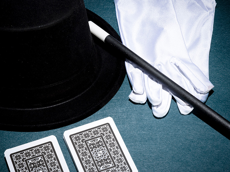 vista-panoramica-de-naipes-guantes-blancos-sombrero-de-copa-y-varita-magica-sobre-fondo-verde